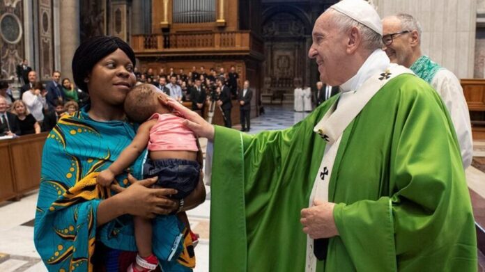 Le pape François bénit un enfant après avoir célébré une messe pour les migrants dans la basilique Saint-Pierre, le 8 juillet 2019, à Rome. © Vatican Media/Reuters